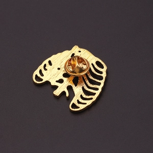 Vue détaillée du dos d'une broche cœur dorée avec fermoir papillon et finition brossée