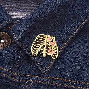 Broche en émail cage thoracique avec roses roses fixée sur le col d'une veste en jean