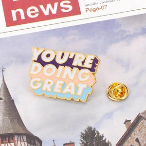 Detailed close-up of You're Doing Great enamel pin with colorful block design and gold metal back