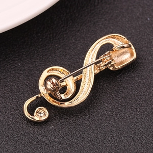Detailed back view of a gold-plated treble clef brooch with secure safety pin clasp