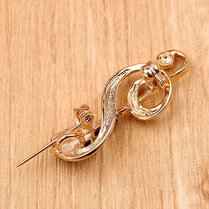 Macro detail of the golden music note brooch reverse side with pin fastening mechanism