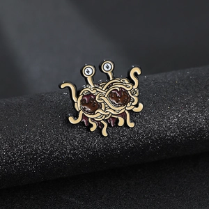 Macro shot of Flying Spaghetti Monster enamel pin on a textured black display base