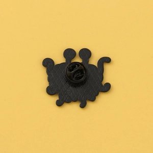 Macro detail of Flying Spaghetti Monster pin back with textured finish and rubber clutch