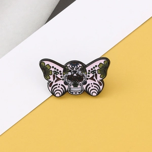 Detailed macro of a butterfly skull enamel pin with colorful sugar skull pattern design