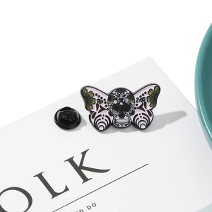 Detail of skull moth enamel pin with pink floral wings and black rubber clutch backing