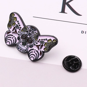 Detail view of purple skull moth enamel pin with floral wings and black butterfly clutch back