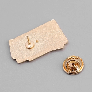 Detail of golden metal brooch back featuring the sharp pin and butterfly clutch fastener