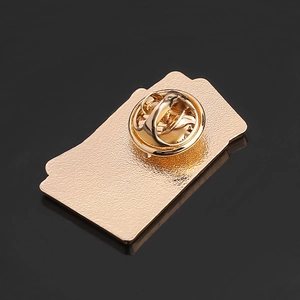 Macro view of gold-plated metal pin back with textured surface and butterfly clutch