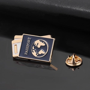 Detail of travel passport enamel pin with gold world map and matching butterfly clutch