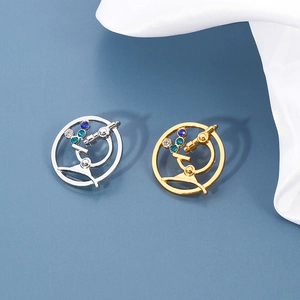 Detailed view of microscope brooches with colorful rhinestones on blue silk background