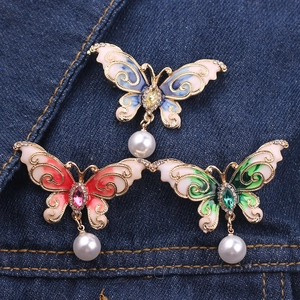 Detailed view of colorful enamel butterfly brooches with rhinestones and pearl pendants
