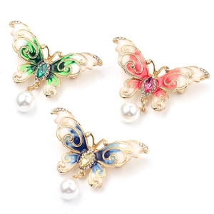 Elegant crystal butterfly brooch with colorful enamel wings and a hanging pearl pendant