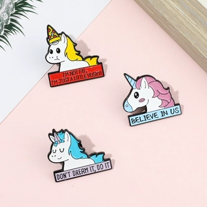 Vue détaillée de trois épingles en émail licorne colorées avec des slogans motivants
