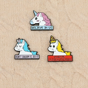 Vue détaillée de pins licorne en émail avec citations motivantes sur tissu en maille