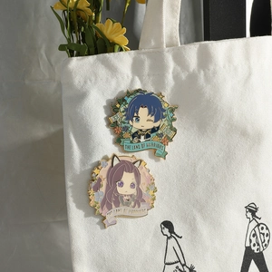 Detail showing Soul Land anime enamel badges with butterfly clasp on a white canvas bag