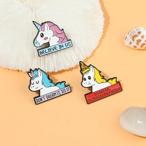 Trois pin's licorne en émail créatifs avec citations motivantes sur socle corail