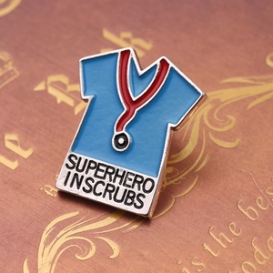 Detail of medical scrubs enamel pin with Superhero in Scrubs text and stethoscope