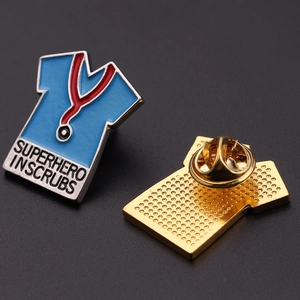 Macro view of blue superhero in scrubs enamel pin with stethoscope and gold metal edge