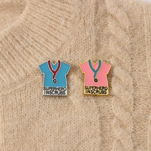 Detail of enamel superhero scrubs pins with stethoscopes on a knitted sweater background