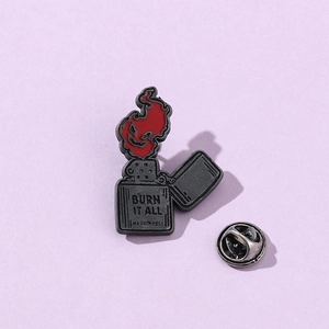Vue détaillée d'un pin's gothique en émail montrant un briquet rouge gravé BURN IT ALL
