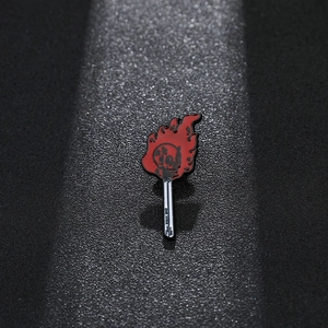 Vue macro d'un pin's émaillé steampunk : allumette en feu avec un crâne en flamme