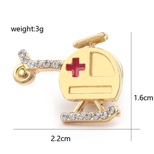 Golden helicopter brooch with white rhinestones and red cross medical badge detail