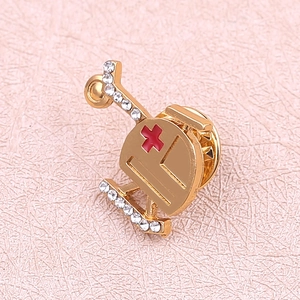 Detail of medical helicopter brooch with red cross and white rhinestones on pink leather