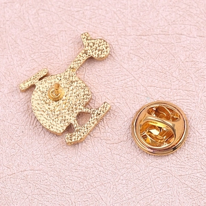 Detail of helicopter pin back showing gold finish texture and butterfly clutch fastener