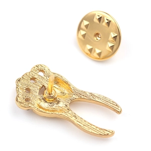 Detail of the golden metal brooch back featuring wavy texture and secure butterfly clutch