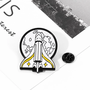 Macro detail of spaceship enamel pin showing silver metallic edges and lunar background