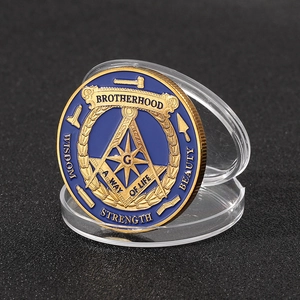 Macro shot of Freemasonry souvenir coin with blue enamel and gold relief in a clear case