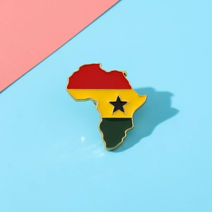 Detail of Ghana flag map brooch with gold metal edges on a pastel background