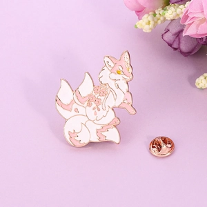 Détail du pin's émaillé renard à neuf queues rose avec motifs de fleurs de cerisier