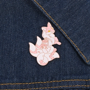 Détail de la broche émaillée renard rose avec motifs cerisiers sur du denim