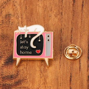 Détail du pin's télé rétro rose avec chat blanc et texte let's stay home sur bois