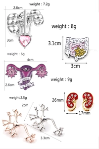 Detailed close-up of anatomical organ brooches featuring colorful enamel and gemstone inlay