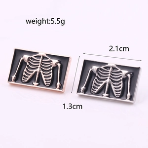 Macro detail of skull rib cage enamel pins showing 2.1cm x 1.3cm product dimensions