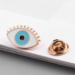 Detailed view of the Evil Eye enamel brooch with gold finish and butterfly clutch back