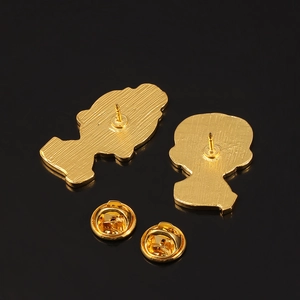 Macro view of gold metal pin back with textured surface and butterfly clutch fastener