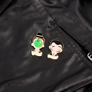 Artistic enamel pins featuring Dali and Magritte on premium black leather backdrop