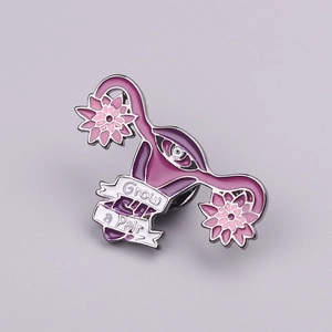 Artistic uterus enamel pin with purple flowers and Grow a Pair slogan detail