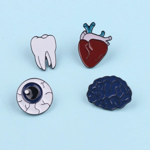 Anatomy enamel pin set featuring white tooth, heart, eyeball, and brain on blue background