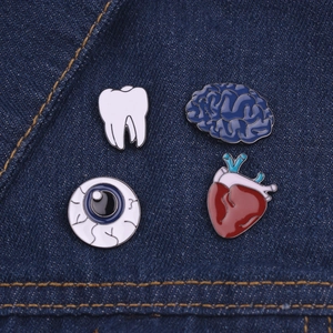 Detailed set of enamel organ brooches including heart and brain on blue denim fabric