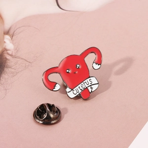 Broche créative en émail en forme d'utérus avec texte Cuterus sur fond rose