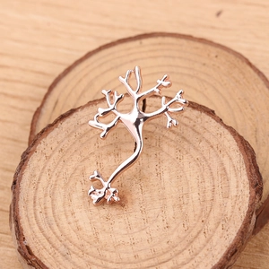 Macro shot of rose gold neuron pin on a natural wood surface with a polished finish