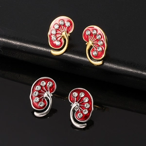 Macro detail of anatomical kidney brooches with red enamel and sparkling crystals