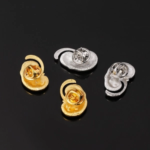 Macro shot of gold and silver organic anatomical pins with detailed hammered metal texture