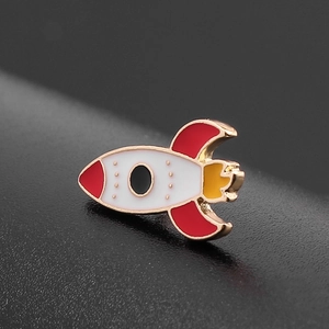 Fashionable colorful rocket enamel brooch with gold alloy edges on black textured background