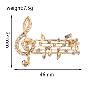 Detailed view of gold music note brooch with crystals measuring 46mm by 34mm