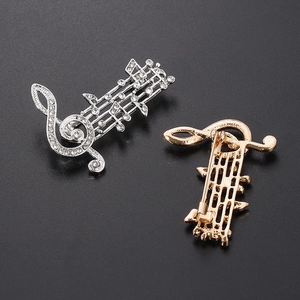 Elegant music note brooch with shimmering crystals in silver and gold metal finishes